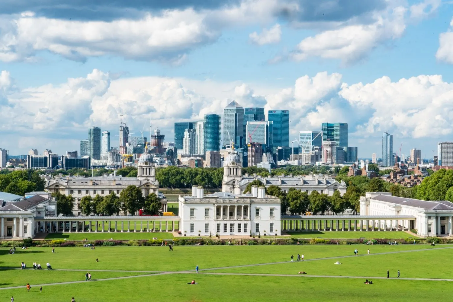 Eine Luftaufnahme der Skyline einer Stadt mit einem grossen weissen Gebäude im Vordergrund.