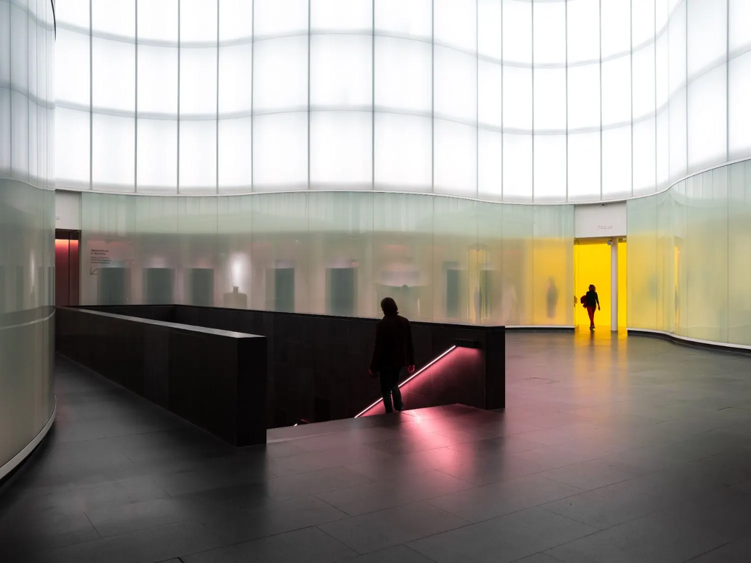 Eine Person geht in einem Gebäude eine Treppe hinunter.