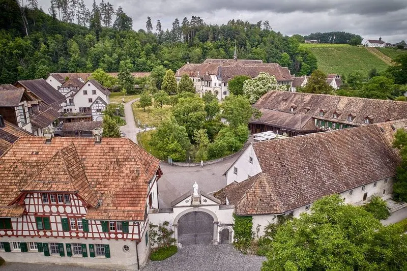 Eine Luftaufnahme eines Dorfes mit Häusern und Bäumen im Hintergrund.