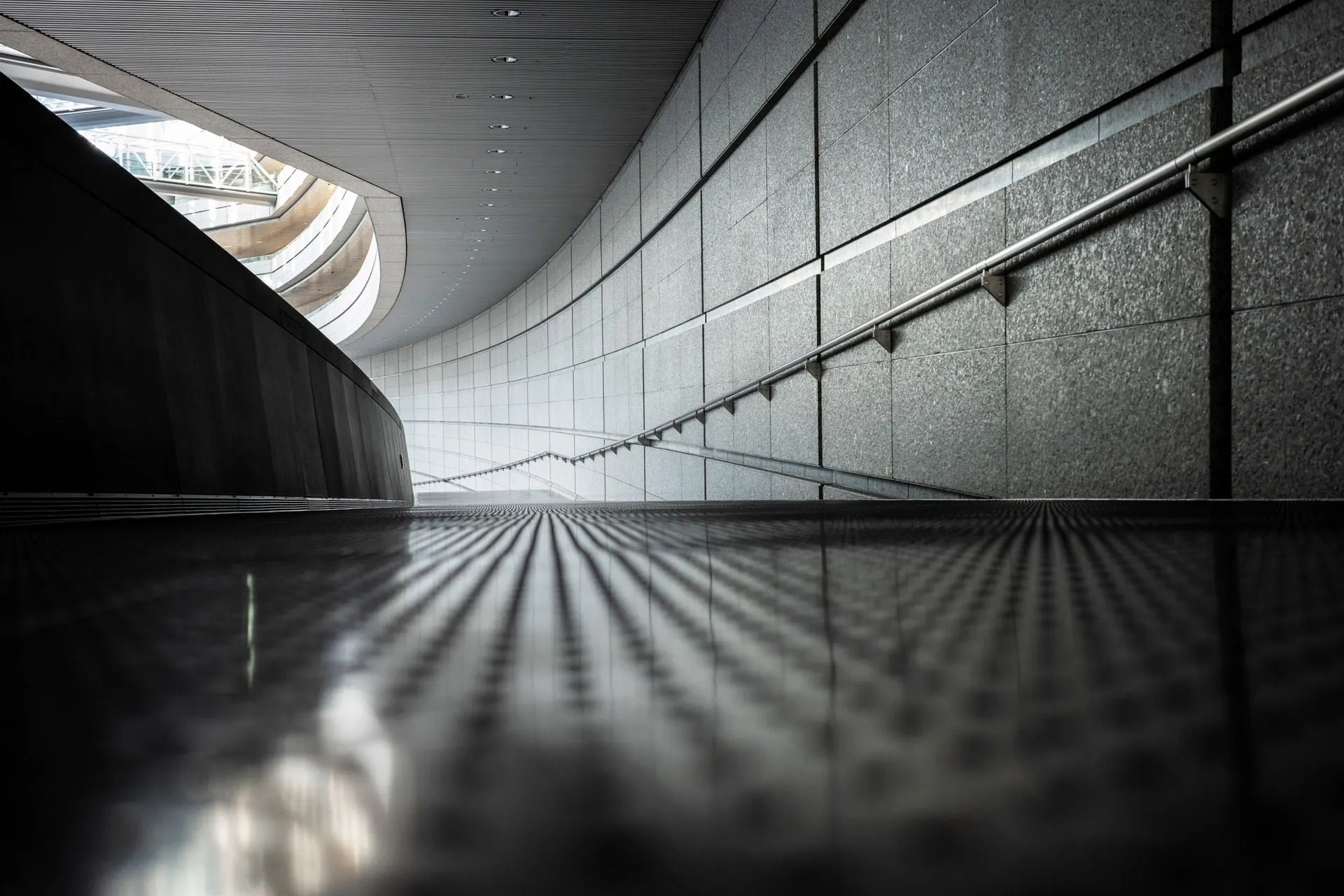 Ein Schwarzweissfoto einer Rolltreppe in einem Gebäude.