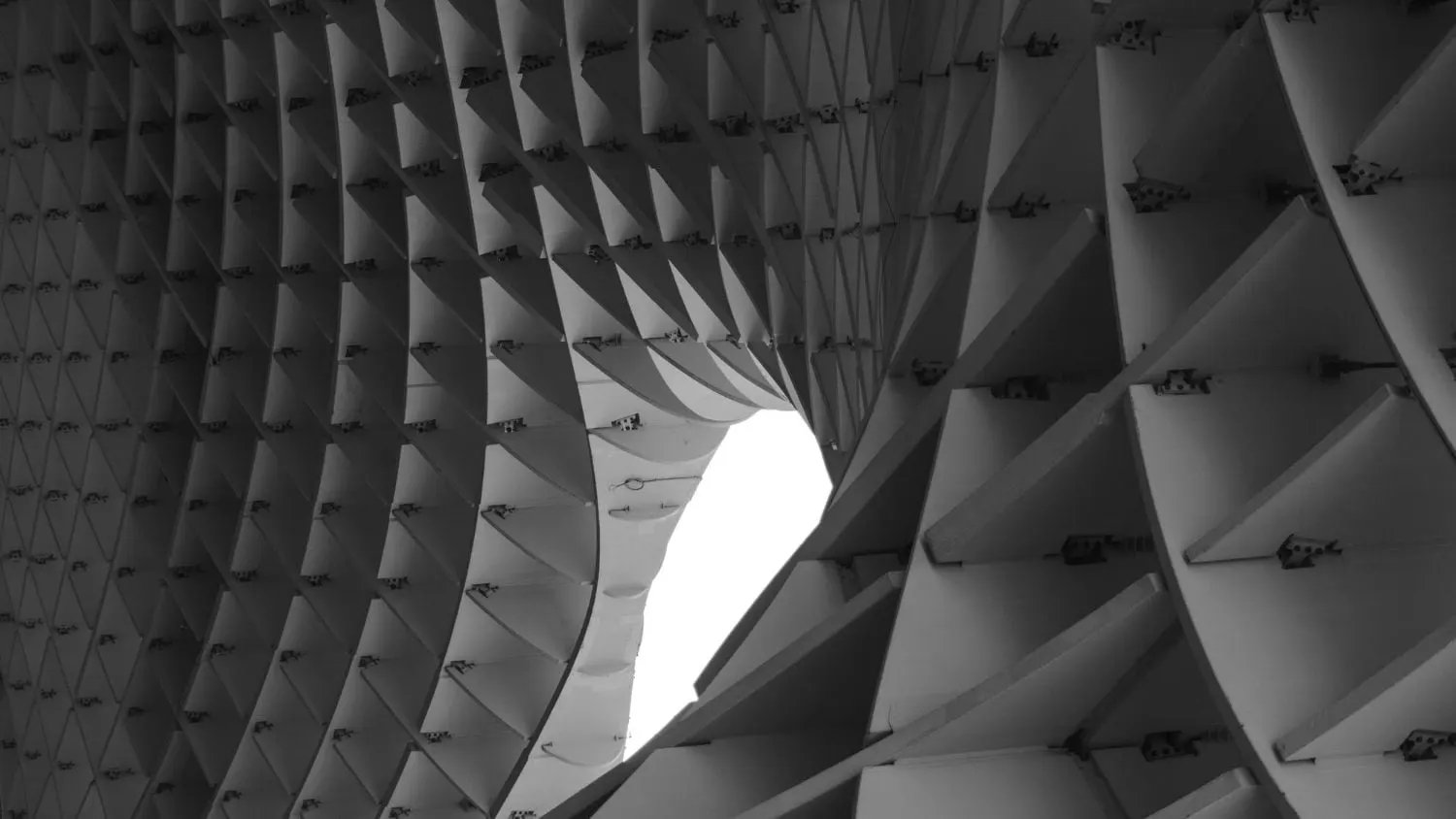 Abstrakte Architekturstruktur mit Wabenmuster, Torbogen und hellem Licht.