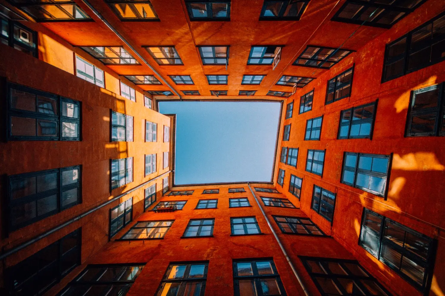 Blick nach oben auf ein Gebäude mit blauem Himmel im Hintergrund.