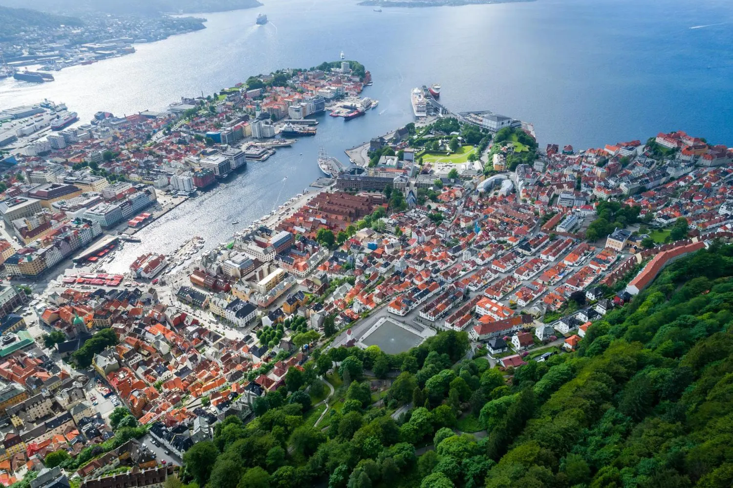 Eine Luftaufnahme einer Stadt, umgeben von Wasser und Bäumen.